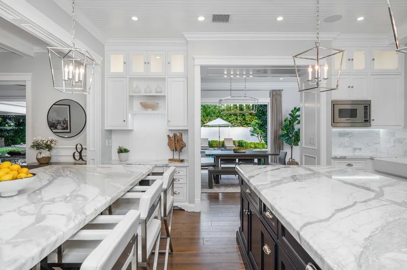 Kitchen remodeling with white cabinets and marble kitchen islands