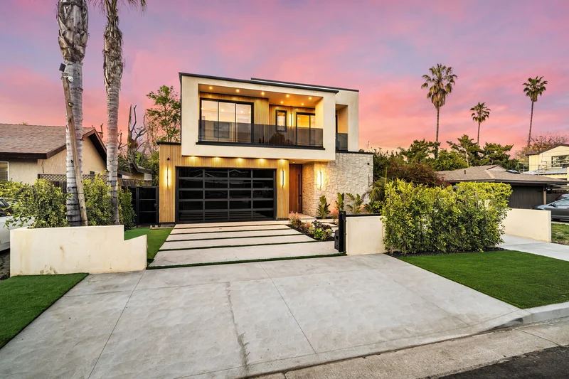 Modern home exterior paint job with glass garage doors at dusk
